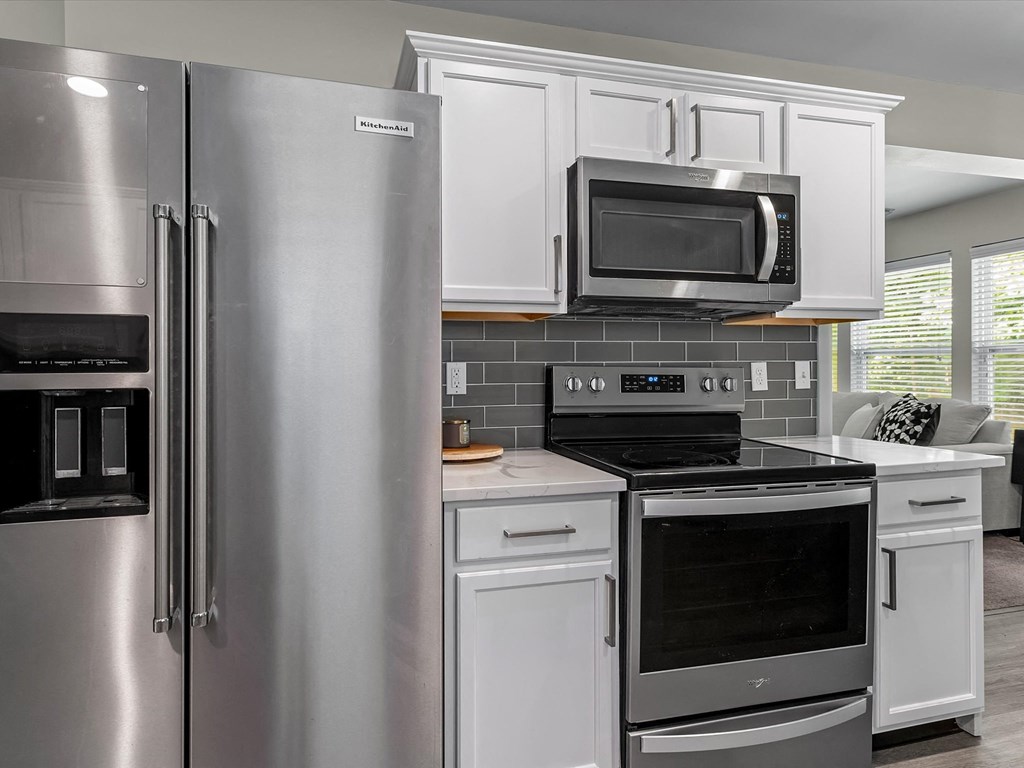 a kitchen with stainless steel appliances and white cabinets