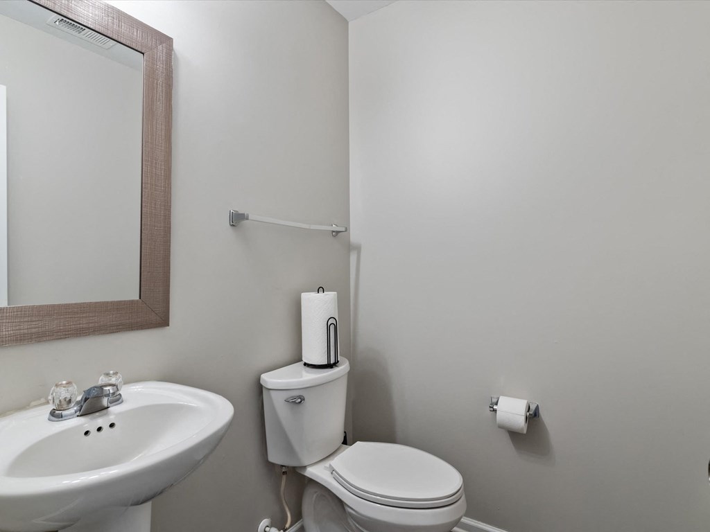 a bathroom with a toilet and a sink and a mirror