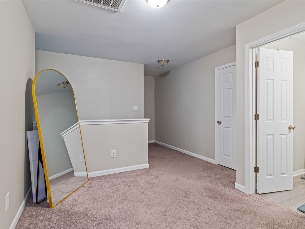 an empty bedroom with a mirror and a closet
