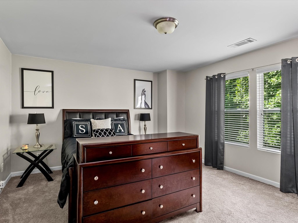 a bedroom with a dresser and a window