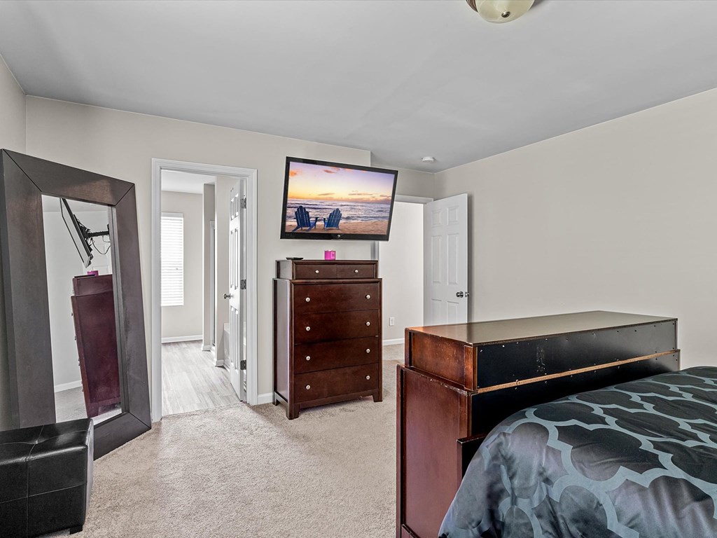 a bedroom with a bed and a dresser and a tv