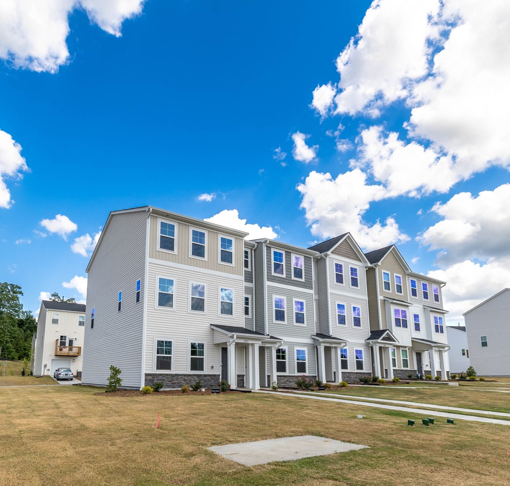 a row of apartment buildings with a blue sky in the background