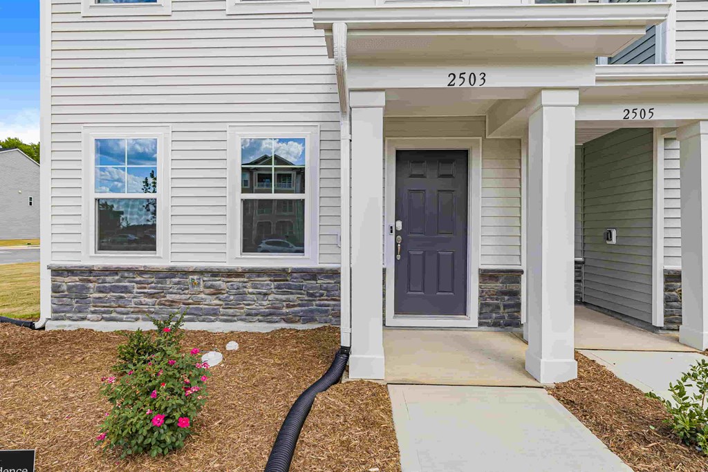 a house with a purple door and a sidewalk in front of it