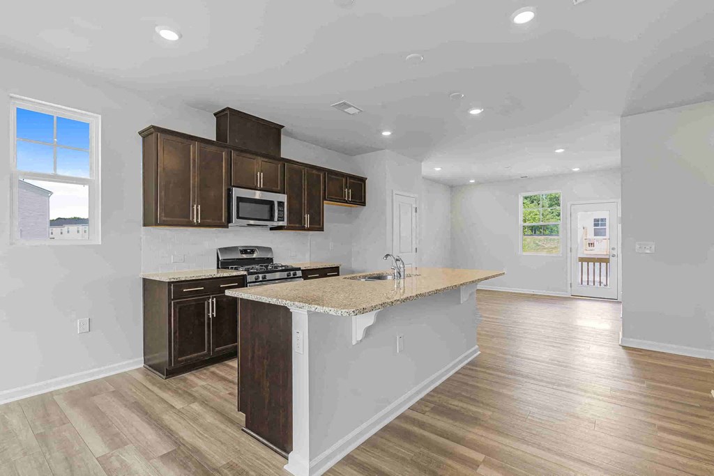 a kitchen with an island and a stove and a microwave