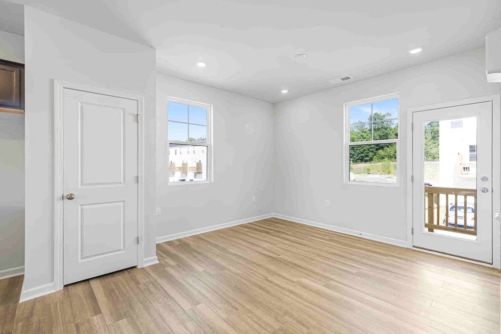 an empty living room with white walls and a white door