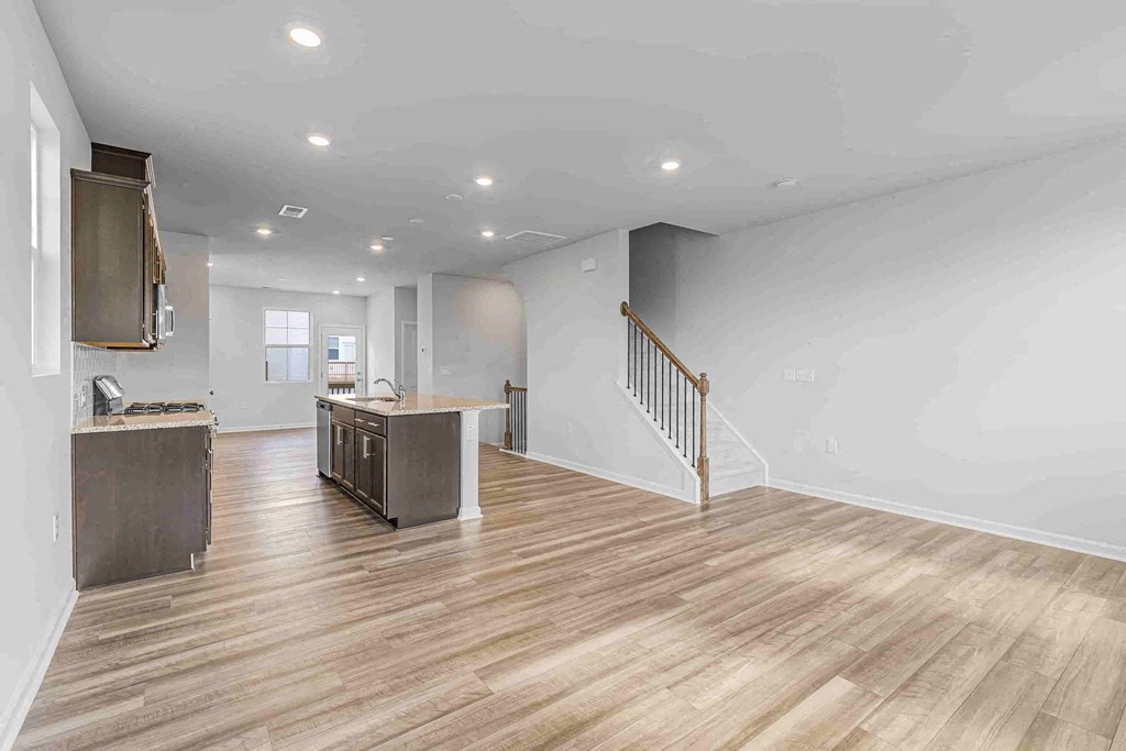 a kitchen and living room with a staircase in a house
