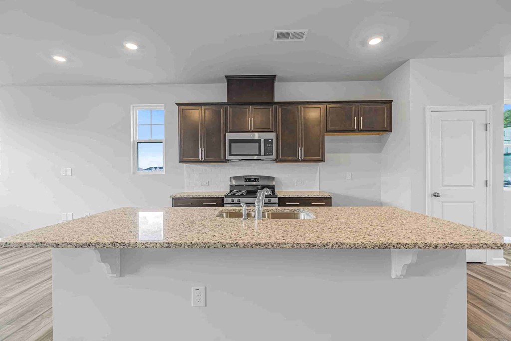 a kitchen with a counter top with a sink and a stove