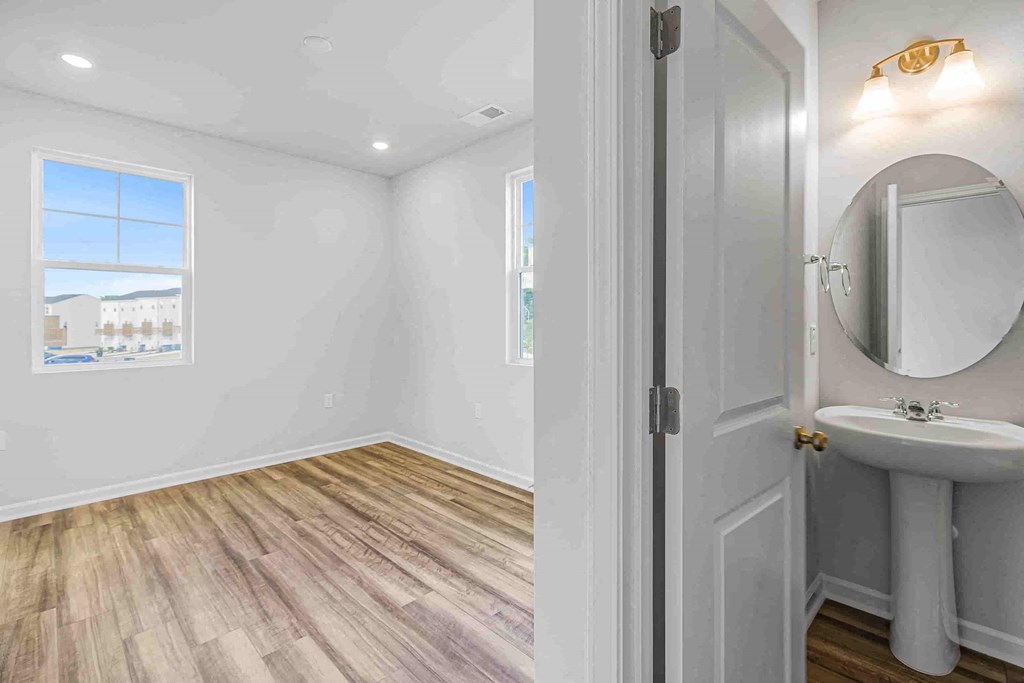 a bathroom with a sink and a mirror in a white room