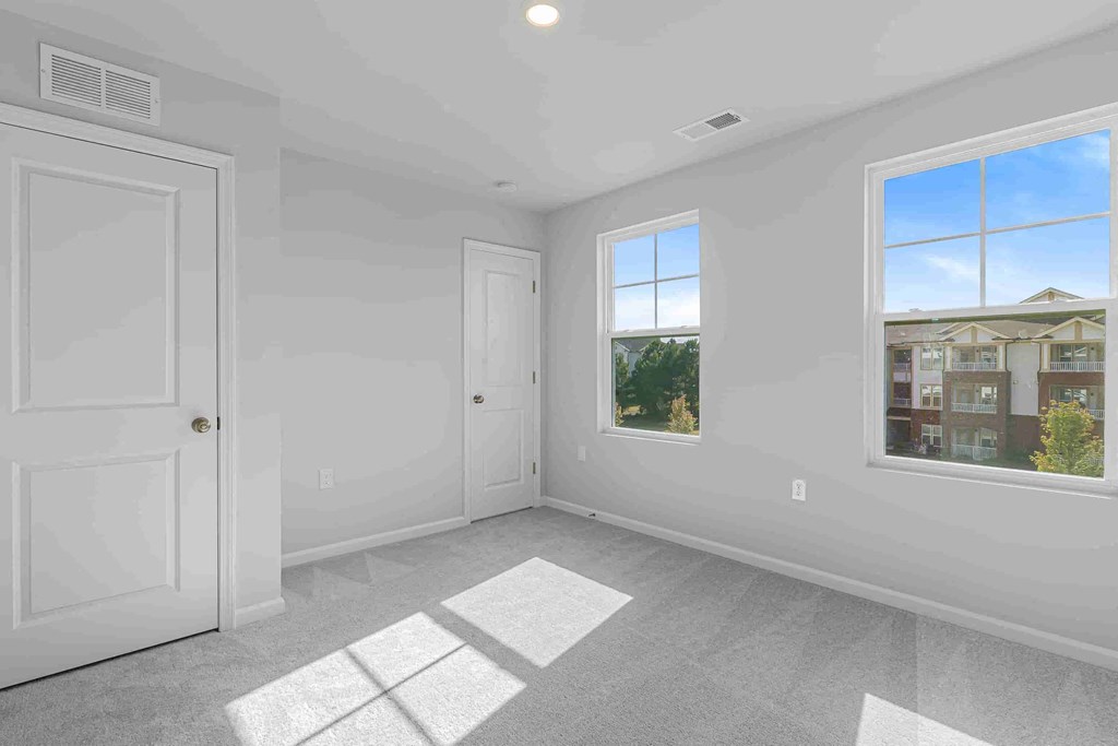 an empty bedroom with a door and a window