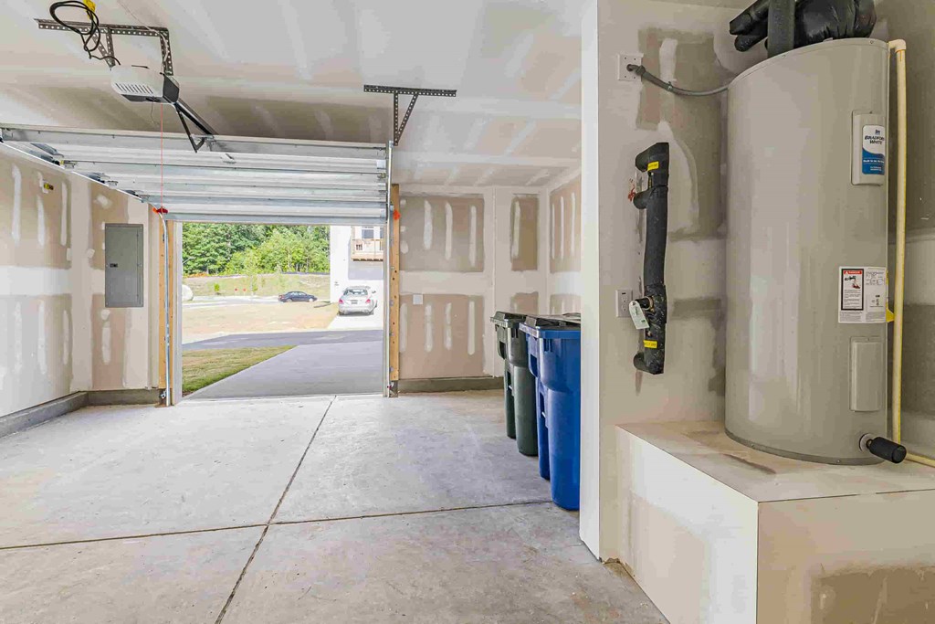 the garage of a building with a water heater and trash cans