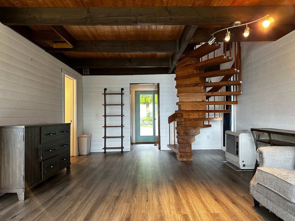 a spiral staircase leads up to a loft in a tiny house