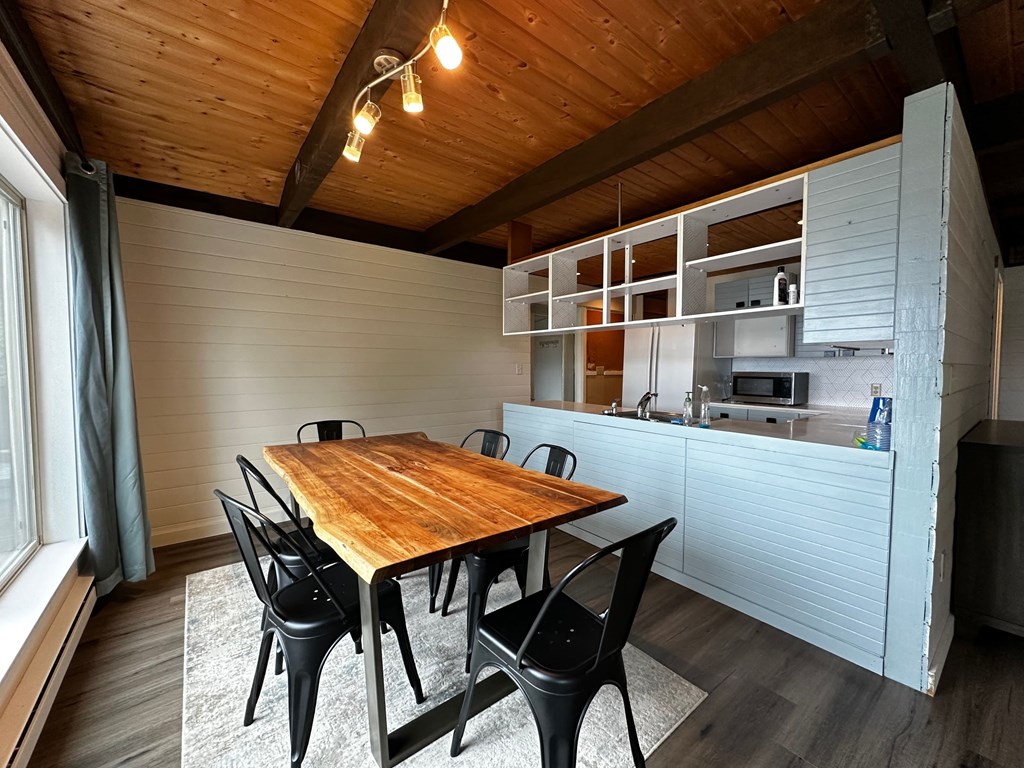 a dining room with a wooden table and a kitchen