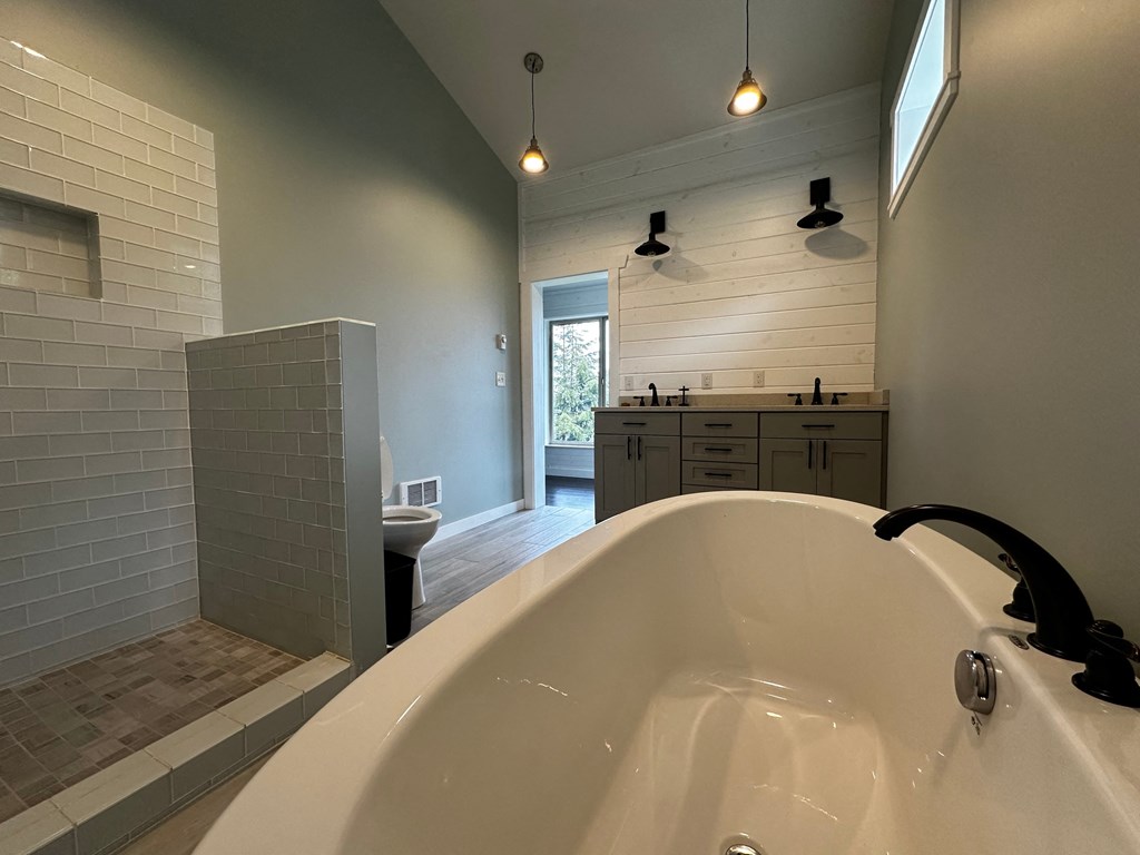 a bathroom with a large tub and a sink and a toilet