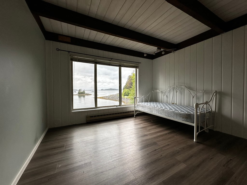 an empty room with a bed and a window