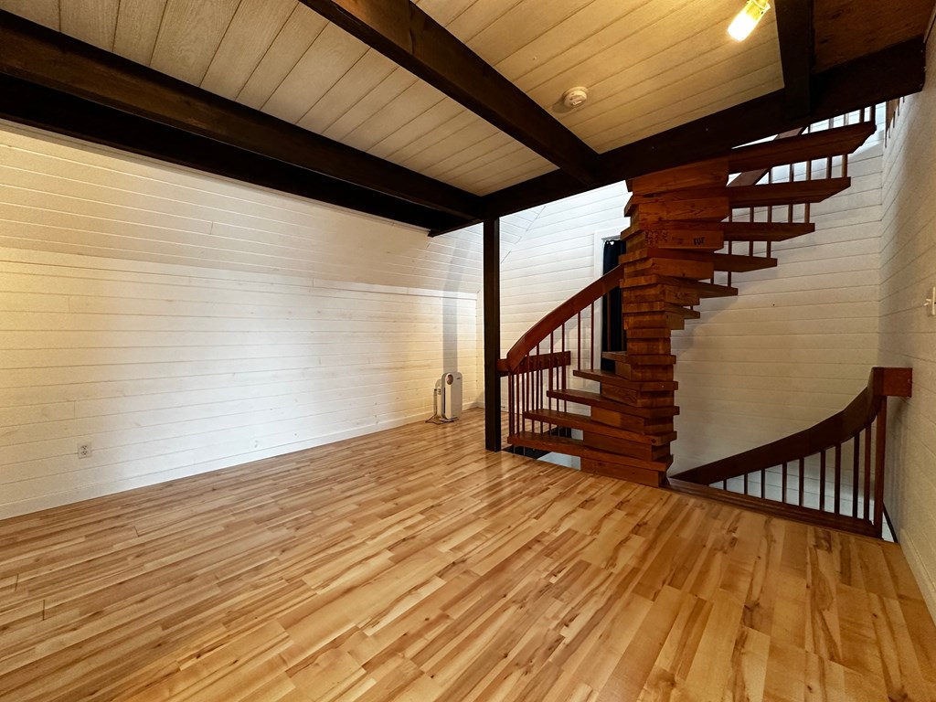 a living room with wood floors and a spiral staircase