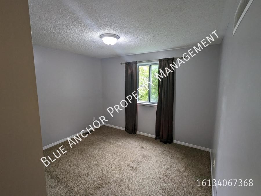a small bedroom with a window and a carpeted floor