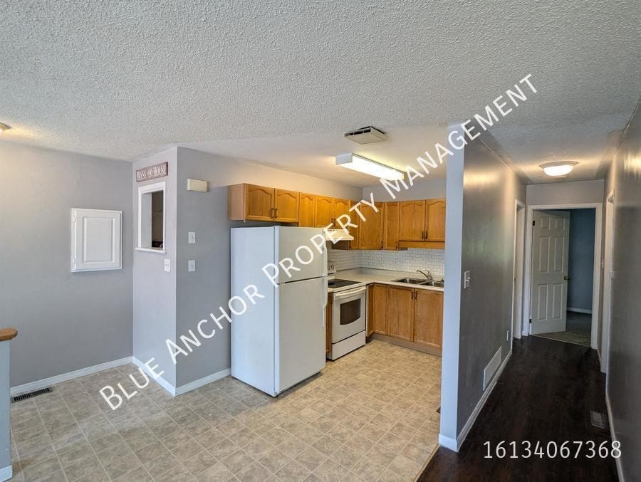a large kitchen with a white refrigerator and a stove