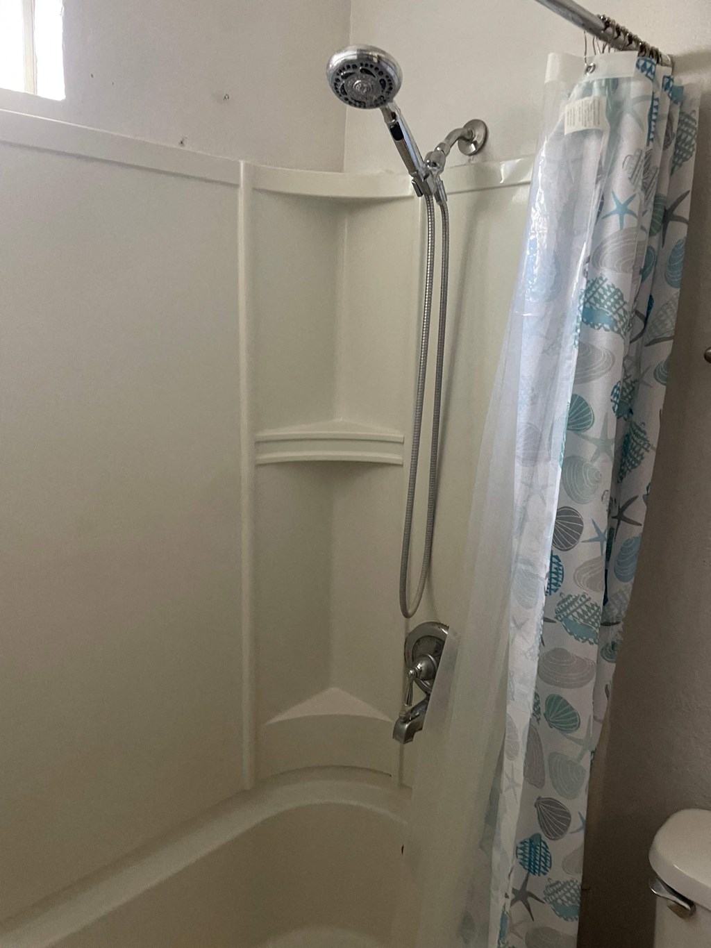 a shower with a shower curtain in a bathroom