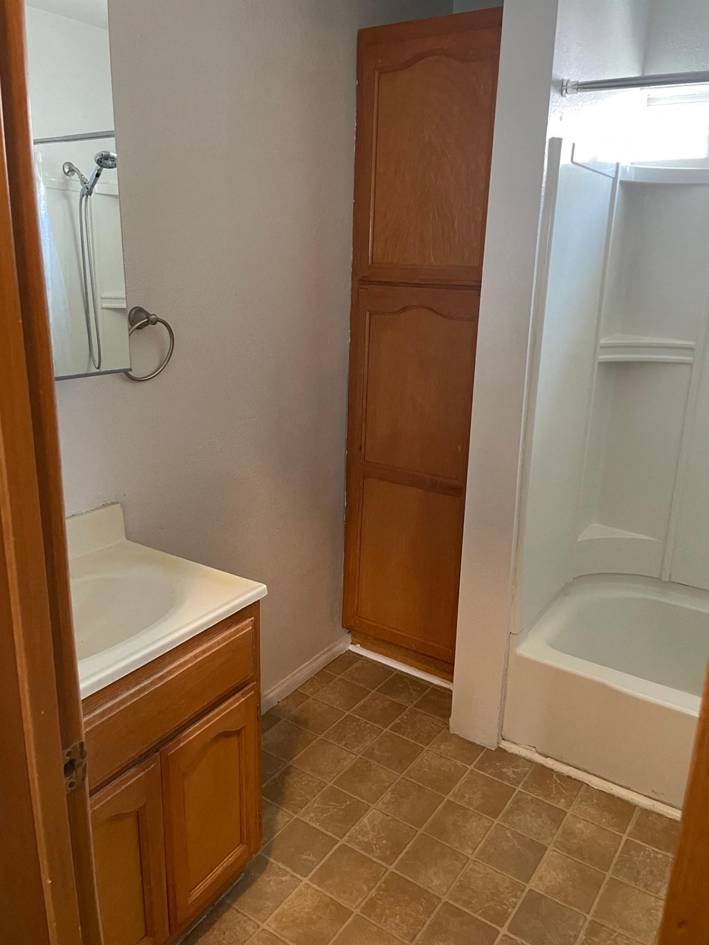 a small bathroom with a sink and a tub and a shower