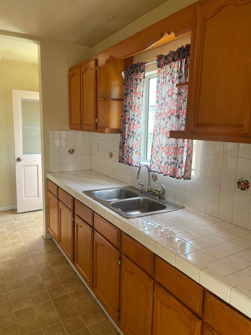 a kitchen with a sink and a window and wooden cabinets