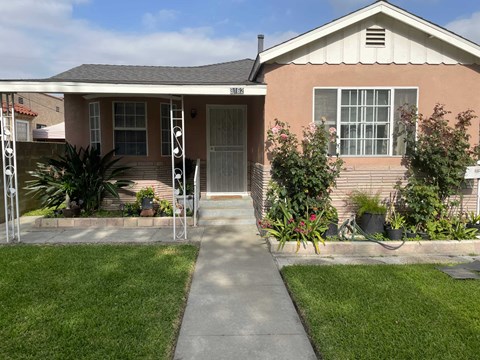 a small house with a sidewalk in front of it