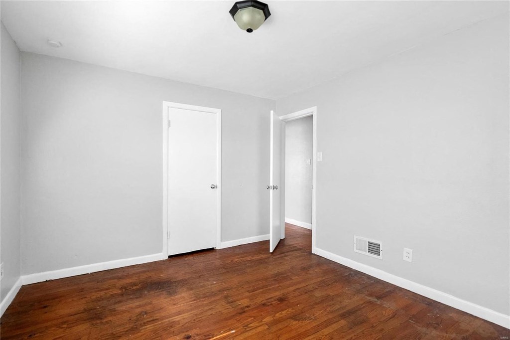 a room with a hard wood floor and white walls