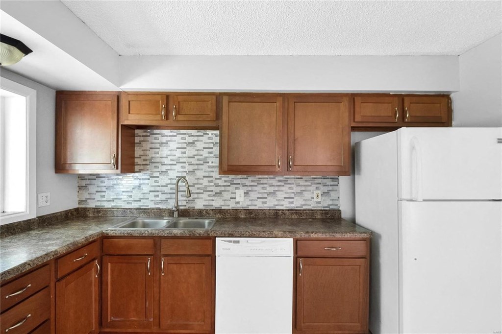a kitchen with wooden cabinets and a white refrigerator