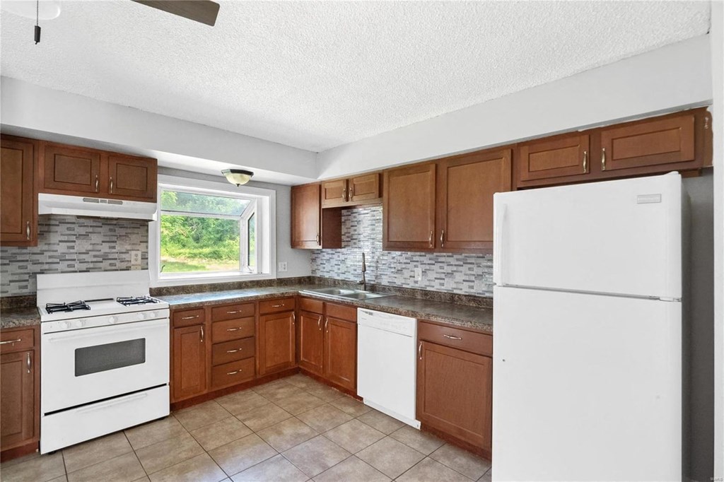 a kitchen with white appliances and wooden cabinets