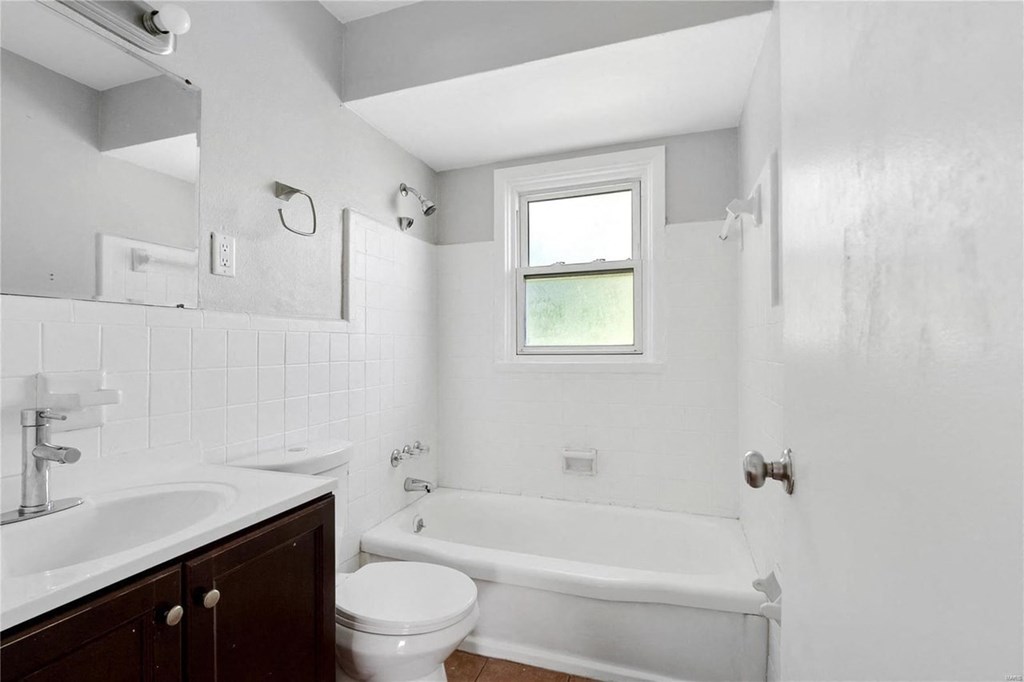 a white bathroom with a tub and a sink