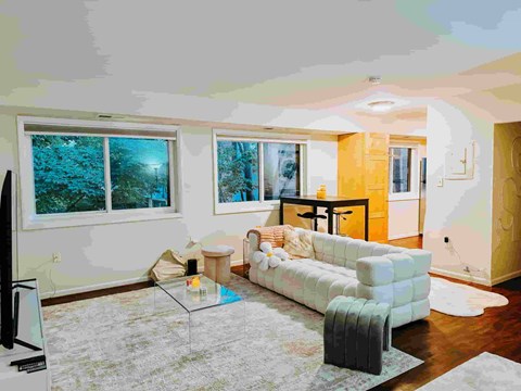 A living room with a white couch and a television.