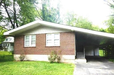 the front of a brick house with a garage