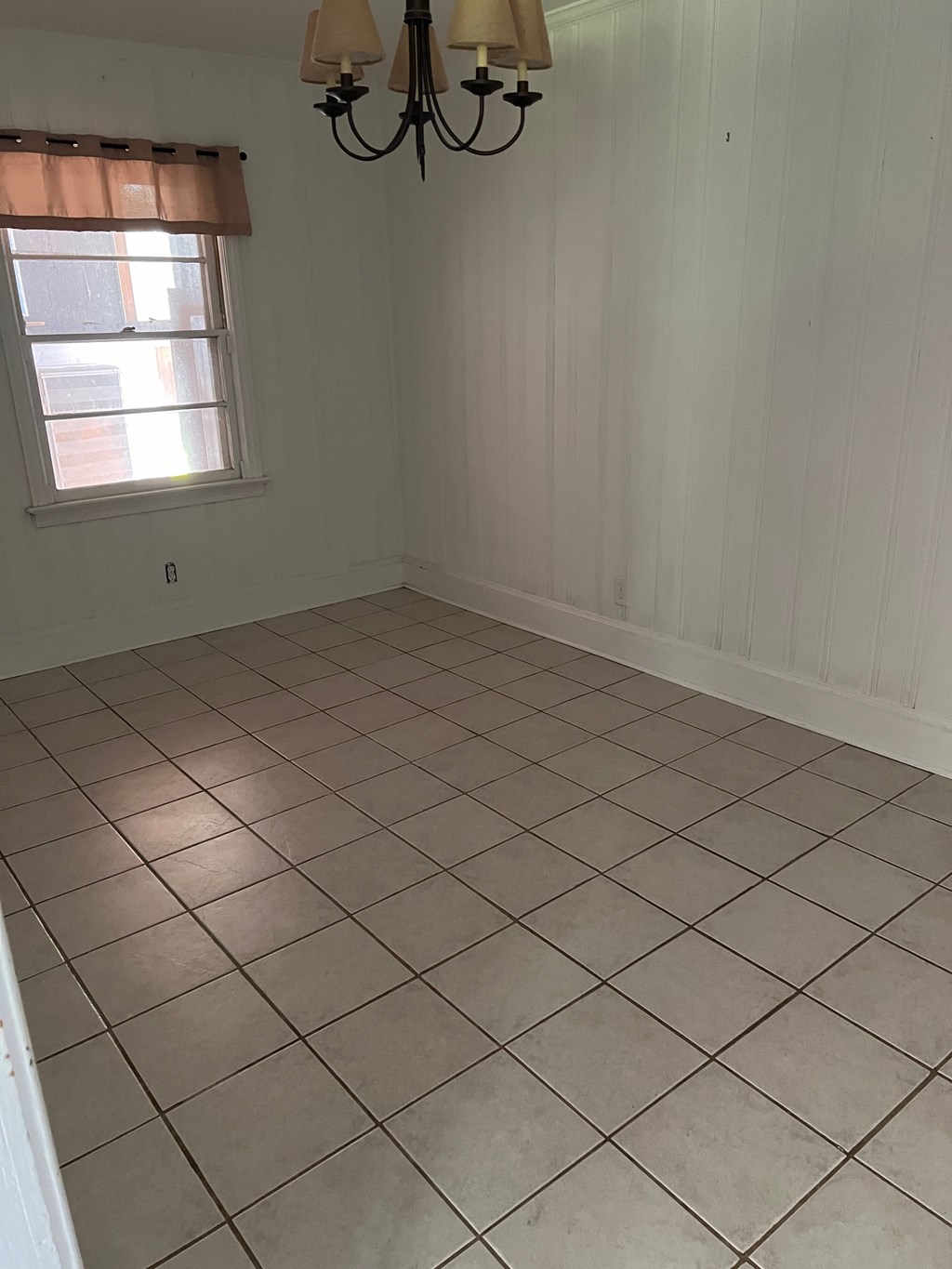 an empty room with a tiled floor and a window