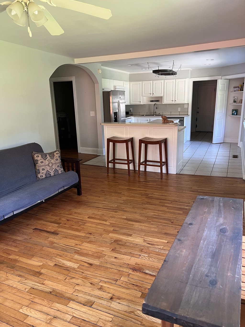 an open living room and kitchen with a wooden floor