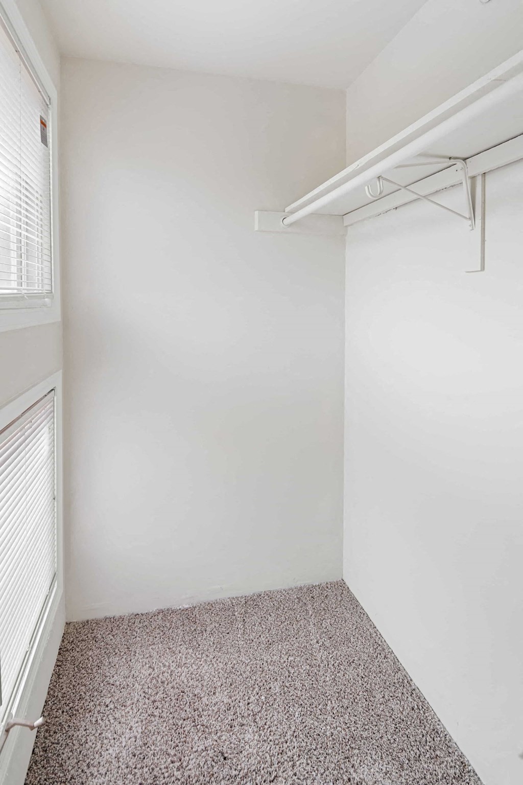 A small, empty room with a carpeted floor and a white wall.