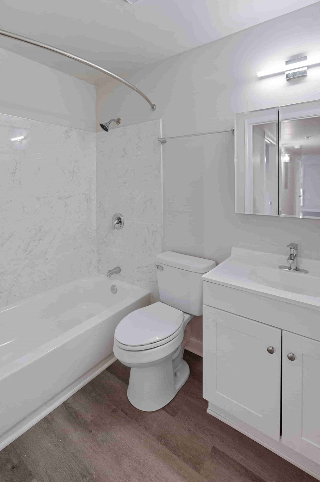 A white toilet sits next to a white sink in a bathroom.