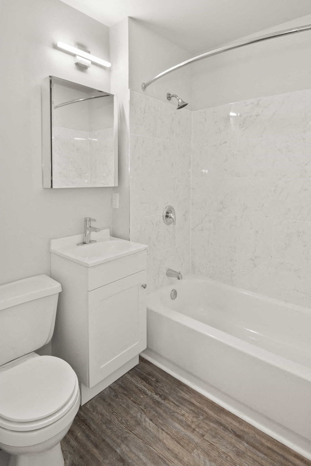A white bathroom with a toilet, sink, and bathtub.