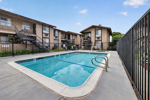 A swimming pool in a residential area surrounded by a fence.