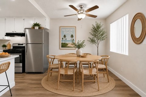 A kitchen with a table and chairs and a fridge.