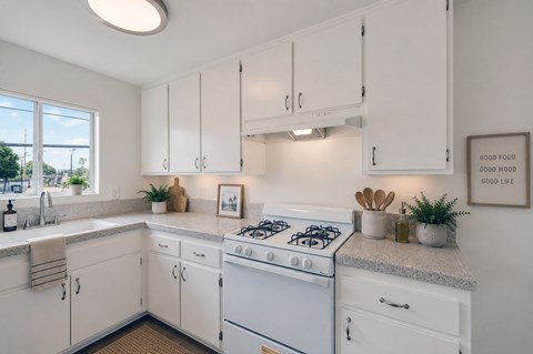 A white kitchen with a stove and cabinets.