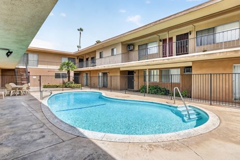 A swimming pool in front of apartment buildings.