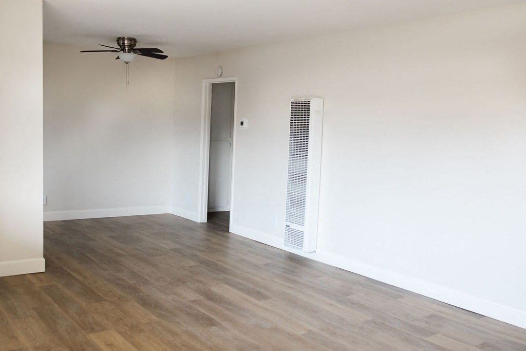 A room with a ceiling fan and a wall-mounted air conditioner unit.