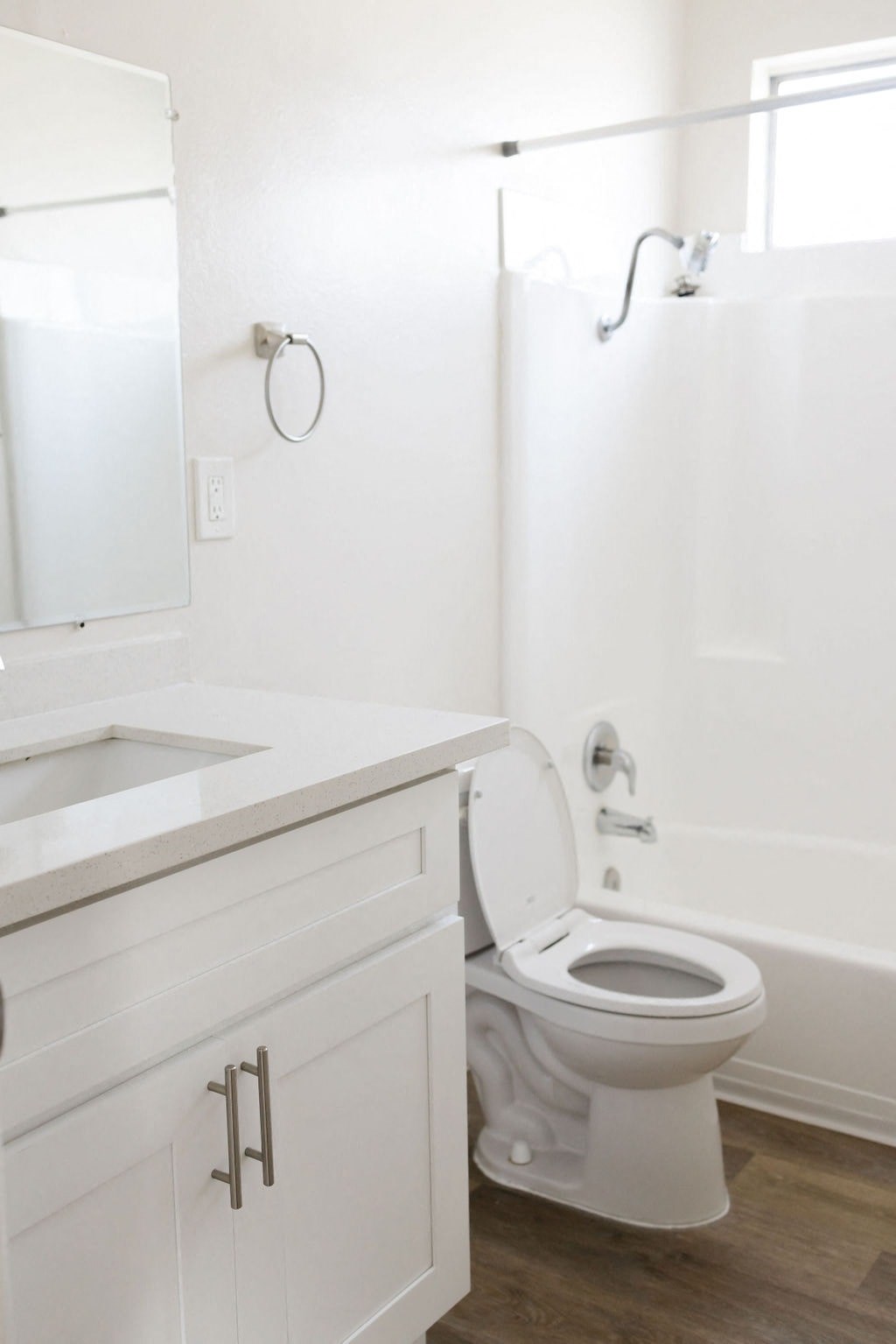A white toilet in a bathroom with a white cabinet and a white sink.
