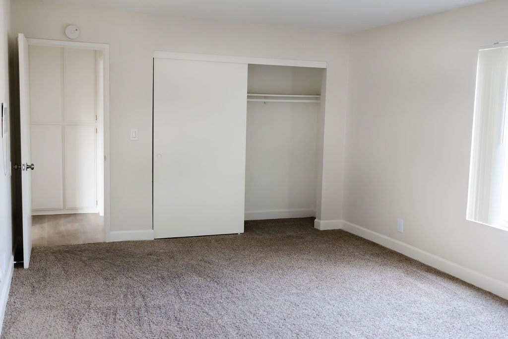 A room with white walls and carpeted floor.