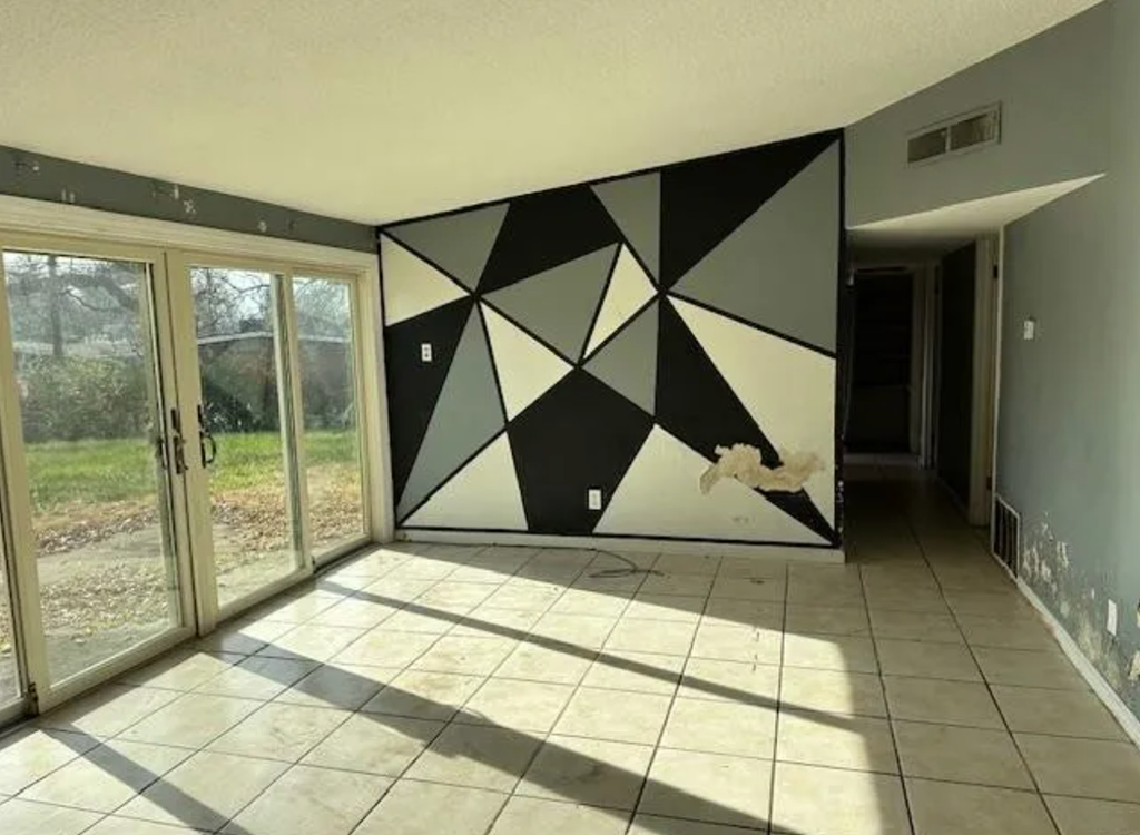 a room with a black and white mural on the wall