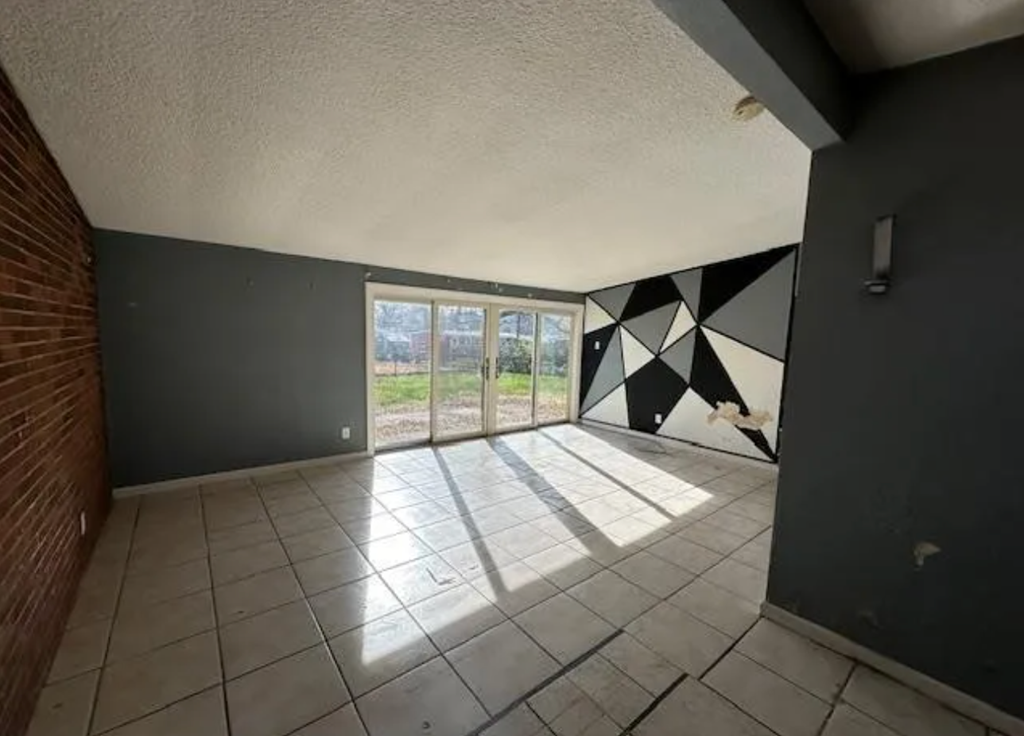 an empty room with a sliding glass door and a tiled floor