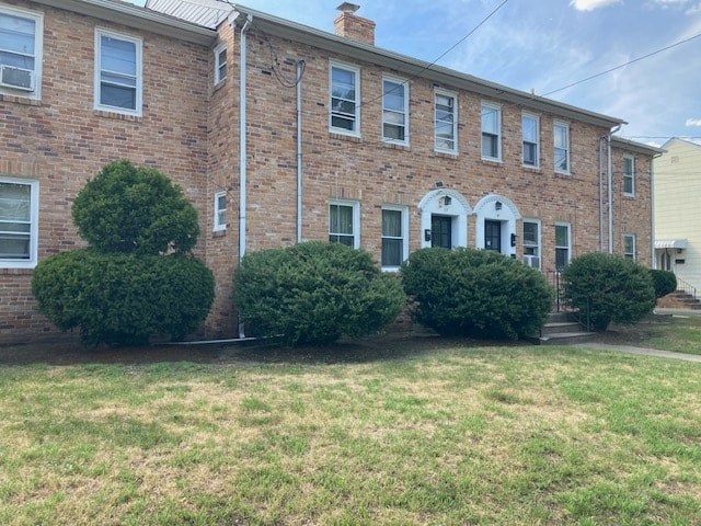 A brick building with a white door and windows.