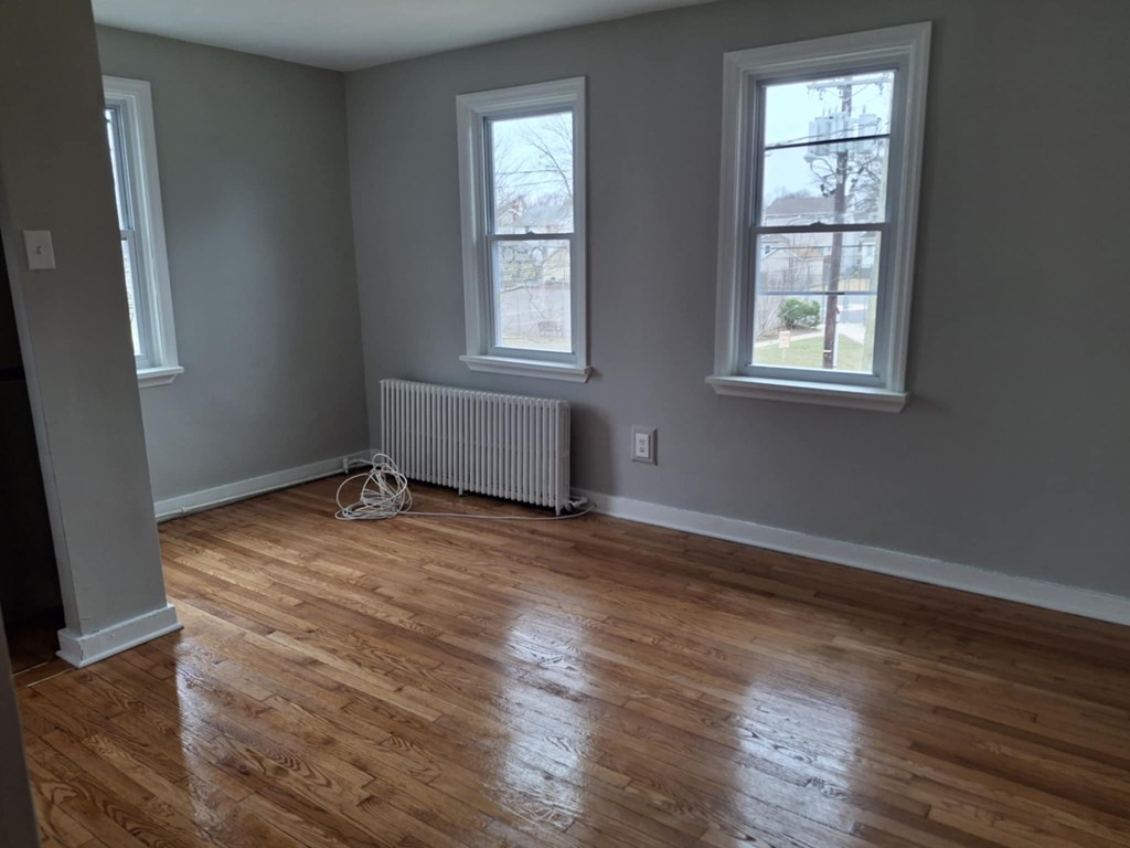 A room with wooden floors and two windows.