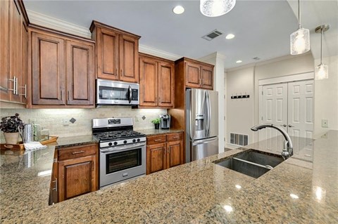 a kitchen with wooden cabinets and stainless steel appliances