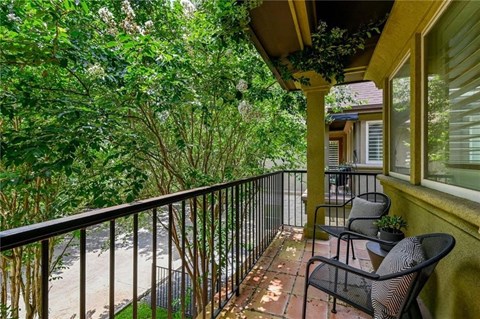 the porch of a home with two chairs on it