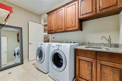 a washer and dryer in a laundry room with wooden cabinets